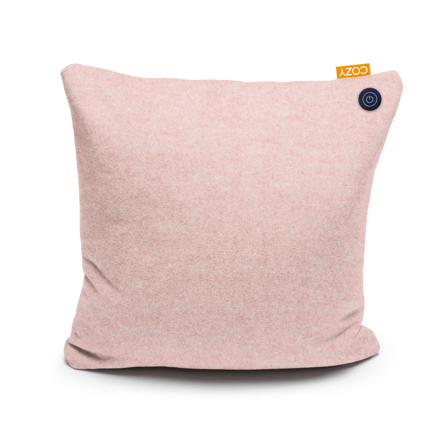 The COZY Heated Cushion Cordless - UNA by Cozy Cushion EU is a square, light pink pillow (45cm x 45cm) with a small orange COZY tag and black button, offering cordless infrared-heated comfort.