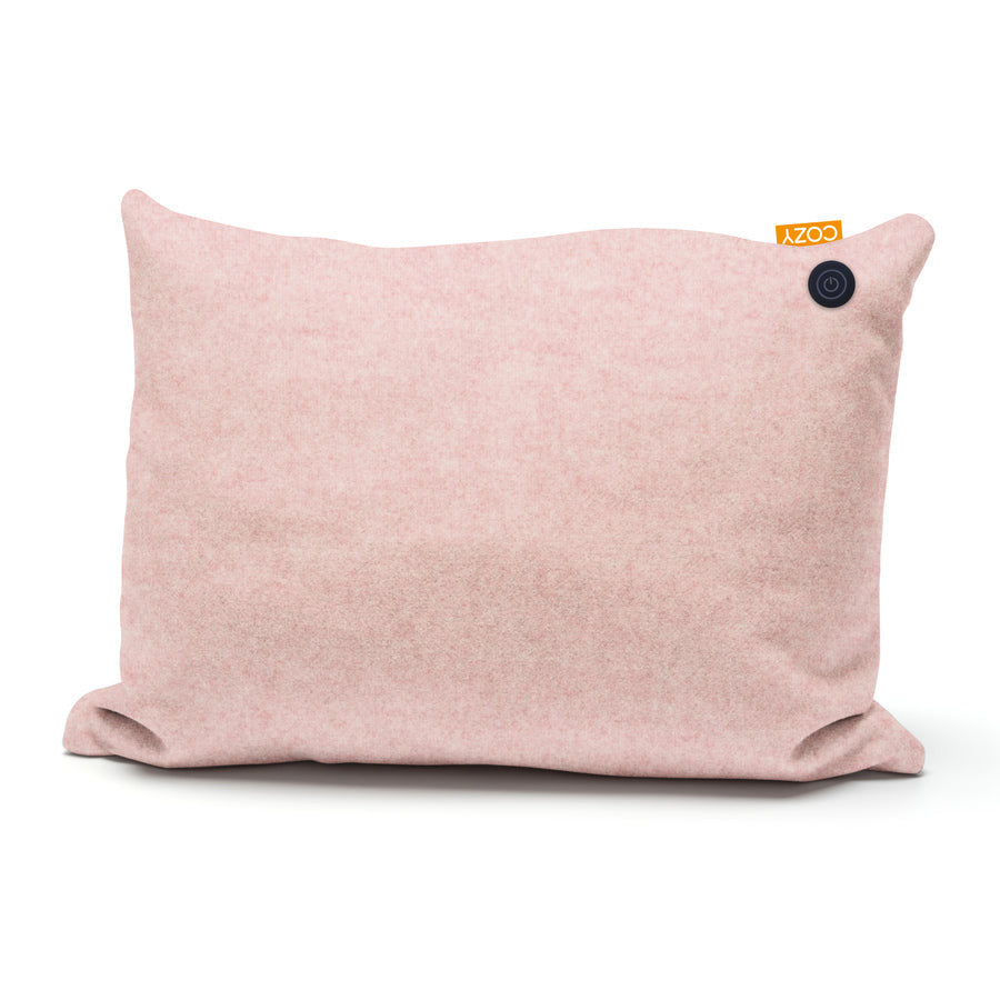 The COZY Heated Cushion Cordless - TOVE by Cozy Cushion EU is a light pink rectangular cushion (60cm x 45cm) with a black button in one corner and a small orange COZY tag at the top right.
