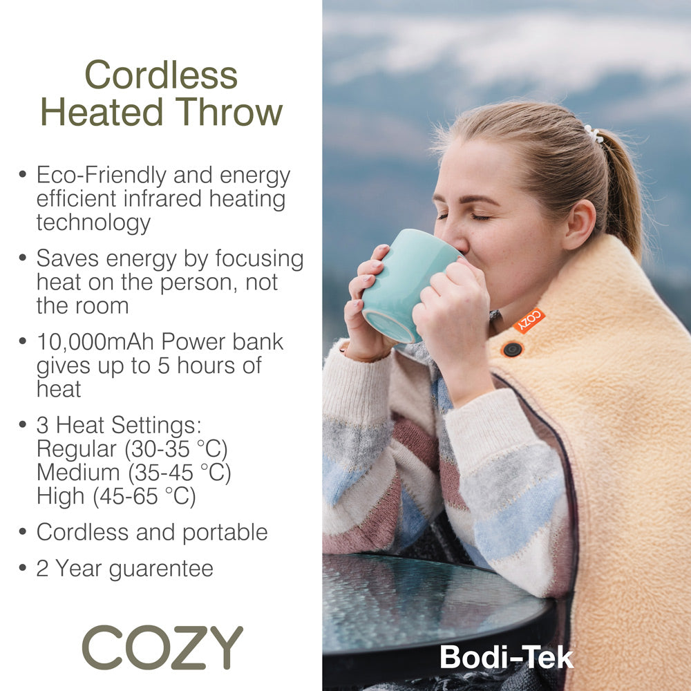 A woman sits outdoors wrapped in the COZY Heated Throw & Seat Cover Pad by Cozy Cushion EU, holding a turquoise mug. Text highlights eco-friendly heating, 3 heat settings, and a cordless, portable design for comfort anywhere.