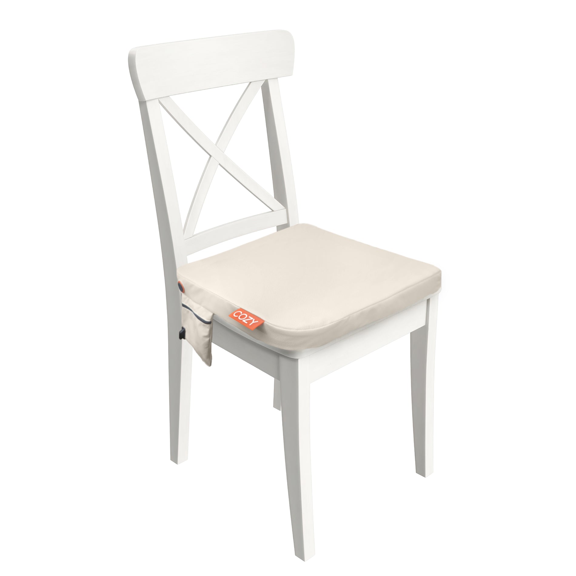A white wooden chair with an X-back design, featuring the COZY Cordless Heated Seat Pad - JORD by Cozy Cushion EU in beige, which has a side pocket labeled “OCOZY” in red.