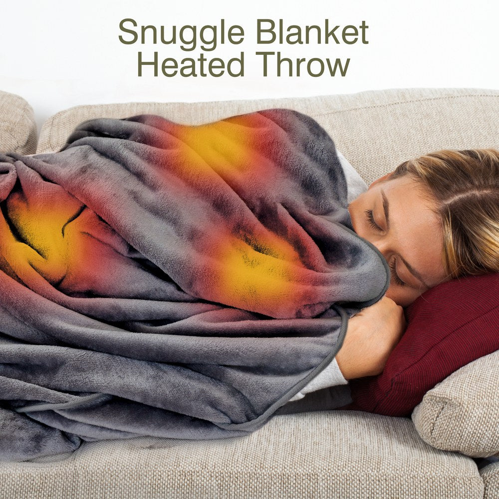 A woman lies on a sofa with her head on a red pillow, wrapped in the Cozy Cushion EU Cozy Wireless Rechargeable Snuggle Blanket Heated Throw, which features glowing warm yellow and orange areas. Text above says, "Snuggle Blanket Heated Throw.