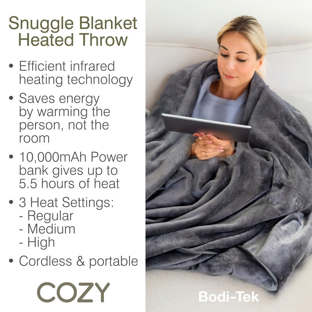 A woman relaxes on a couch with the Cozy Cushion EU Cozy Wireless Rechargeable Snuggle Blanket Heated Throw, featuring efficient infrared heating, energy saving, 10,000mAh power bank, three heat settings, and cordless portability.